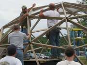 people building a geodesic dome greenhouse