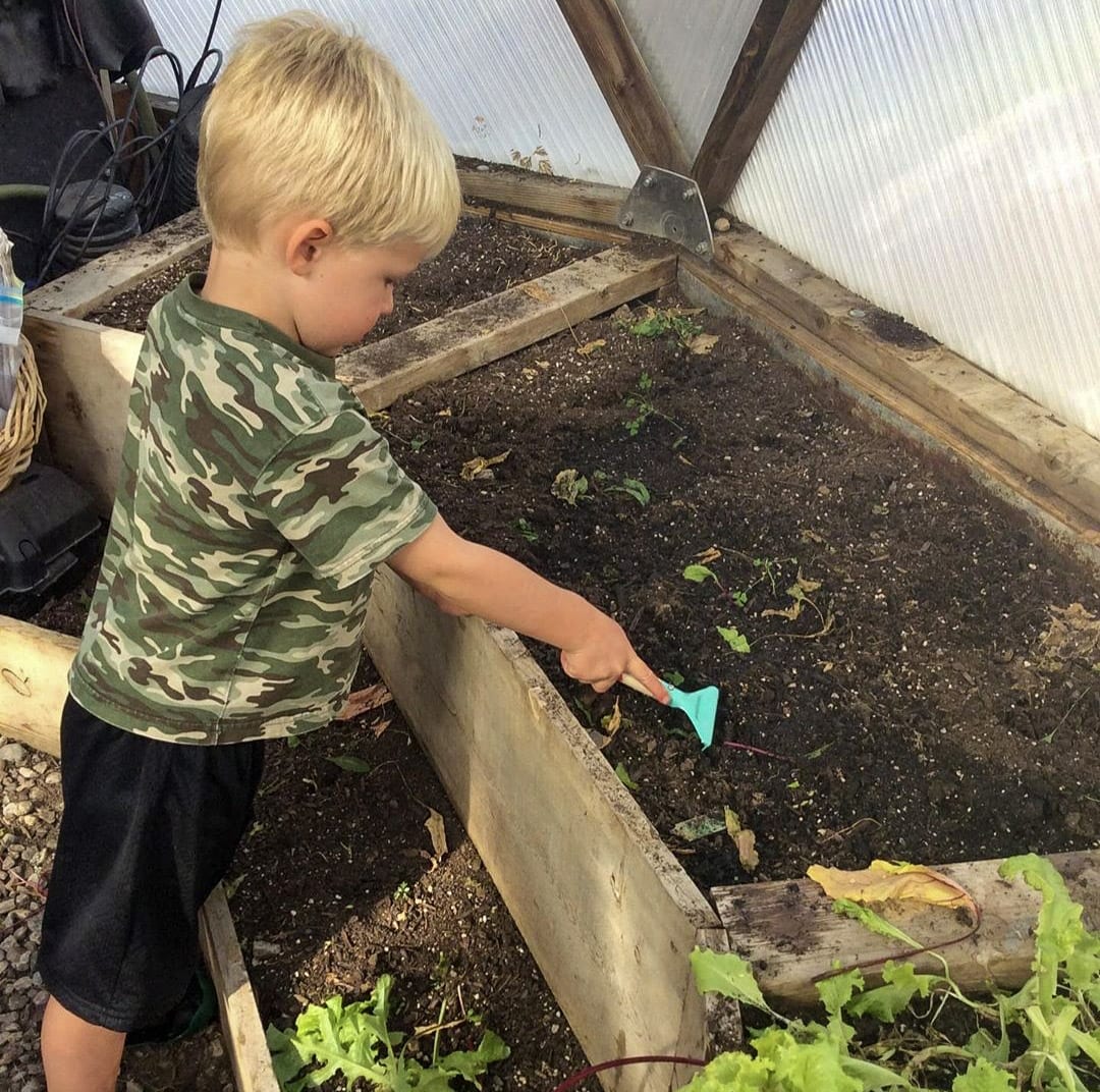 Kid gardening in a Growing Dome Greenhouse