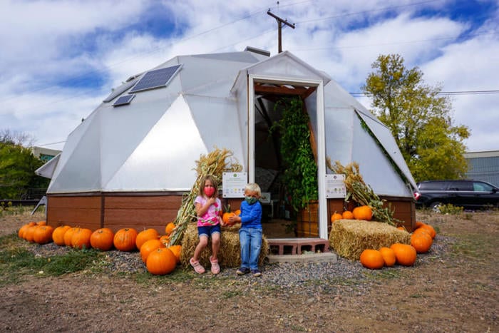kids with pumpkins outside dome greenhouse in Golden Colorado