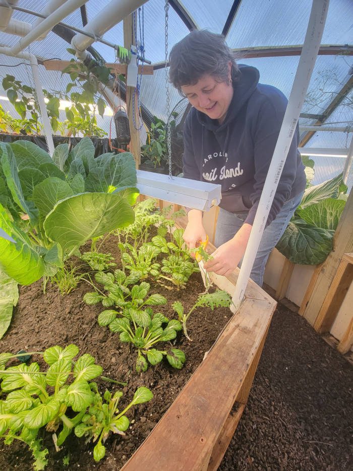 Emy tending to her greenhouse garden