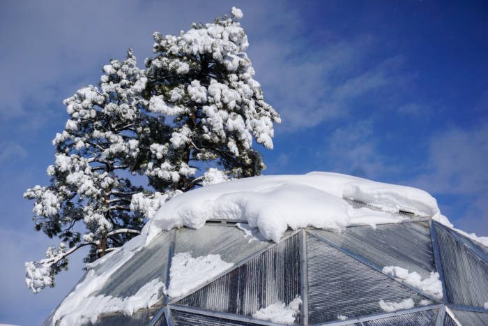 snow melting off the top of a polycarbonate geodesic greenhouse