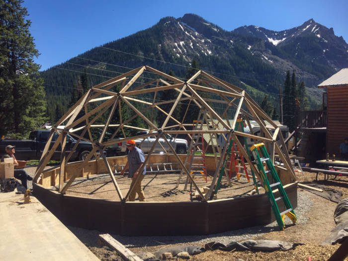 people building a geodesic dome greenhouse classroom in montana