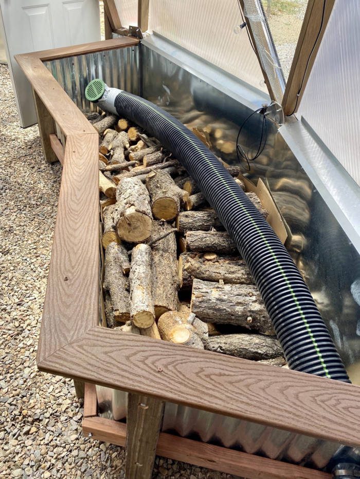 logs for hugelkultur in raised beds wth climate system tube