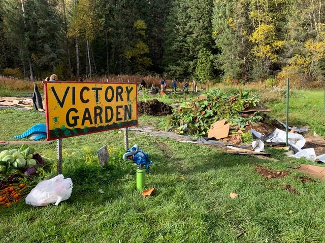 victory garden sign with victory garden and compost in the background