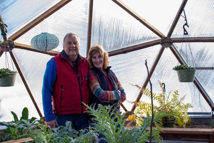 Joe and Nancy Drake in their backyard greenhouse