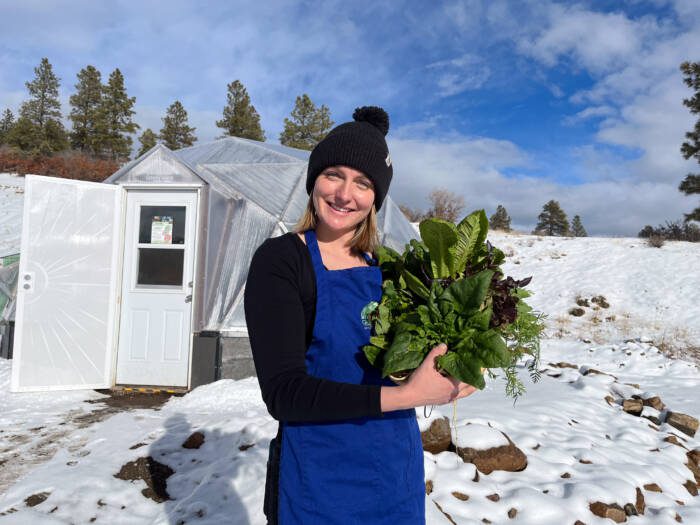 Survival gardener in snow with fresh picked produce
