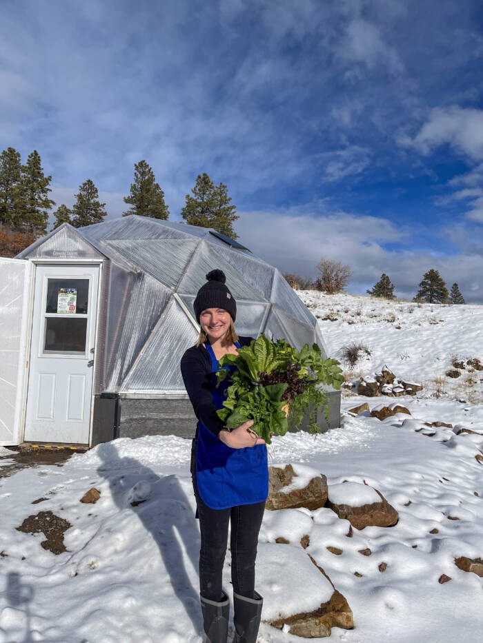 girl holding winter produce harvested from a deep winter greenhoues 