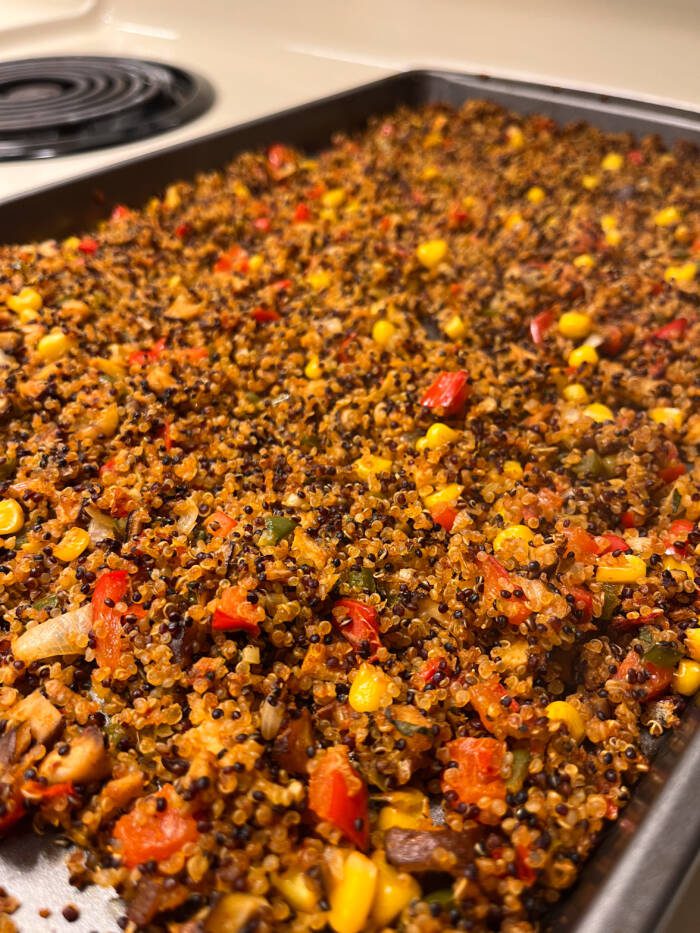 Vegan taco meat made with quinoa, mushrooms, peppers, corn, and onions toasted in the oven on a sheet pan.